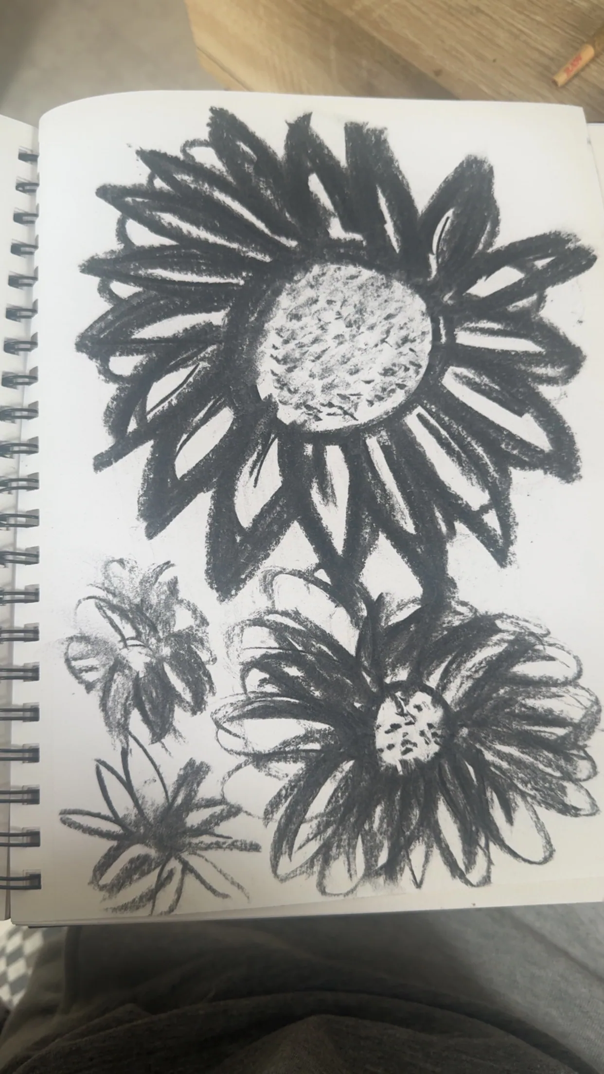 Charcoal drawing of sunflowers in a sketchbook