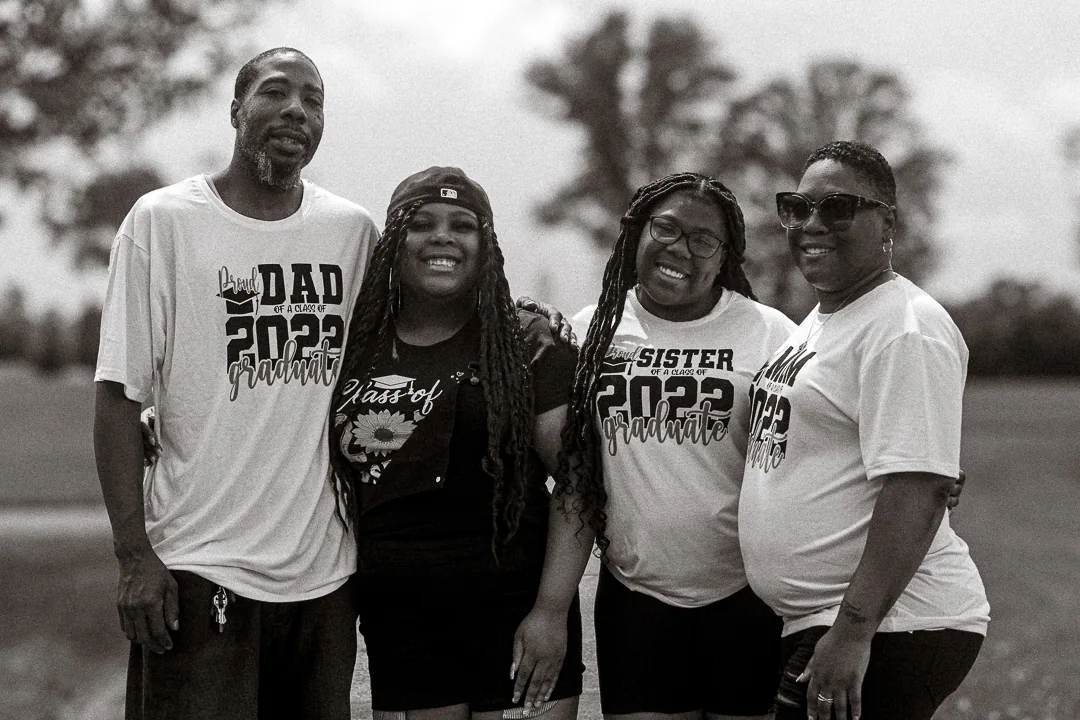 Black and white family group portrait taken outdoors